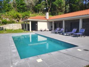una piscina con sillas azules y una casa en Casa do Alambique en Alvaredo
