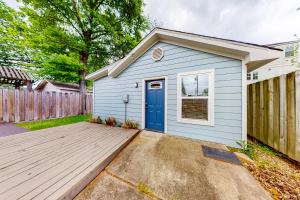 a blue shed with a blue door in a yard at The Heights Garden Cottage in Houston