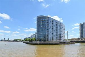 ein hohes Gebäude auf der Seite eines Flusses in der Unterkunft Modern 2Bed Apartment London Cutty Sark O2 Arena Greenwich - Perfect for long stays in London