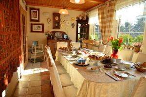 a dining room with a long table with food on it at Pensjonat B&B Nad Rudawą in Kraków