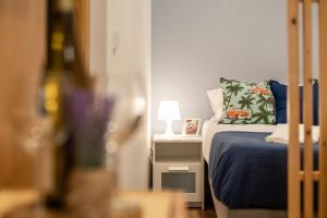 1 dormitorio con 1 cama y mesita de noche con lámpara en 733 Costa Cabral Metro Residence, en Oporto