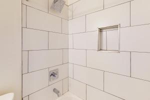 uma casa de banho em azulejos brancos com uma janela e um lavatório em Cherry Avenue Studio em Tucson