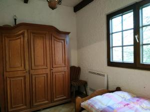 um quarto com um armário de madeira e uma cama em Maison de vacances Diff em Puttelange-aux-Lacs