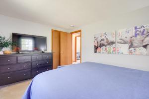 a bedroom with a large bed and a tv at Picturesque Barnstable Rental with Deck and Backyard! in Barnstable