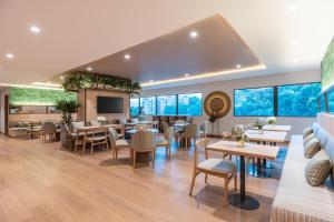 un restaurante con mesas, sillas y TV en Fairfield by Marriott Medellin Sabaneta, en Medellín