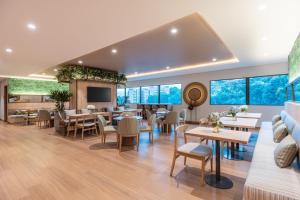 un restaurante con mesas, sillas y TV en Fairfield by Marriott Medellin Sabaneta en Medellín