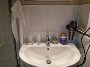 un lavandino bianco in bagno con occhiali di Waldhaus Dötlingen Ferienhaus im Naturpark a Dötlingen Altre 45 foto