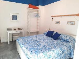 a bedroom with a blue and white bed and a desk at Il Sogno Apartments in Monterosso al Mare