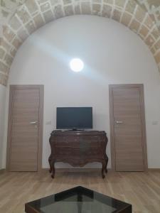 a living room with a tv and a wooden table at La Coccola in Leporano
