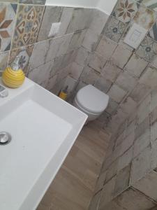 a bathroom with a white sink and a toilet at La Coccola in Leporano +3 photos