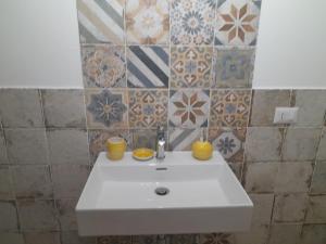 a white sink in a bathroom with tiles at La Coccola in Leporano