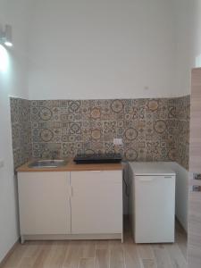 a kitchen with a counter and a sink and a wall at La Coccola in Leporano