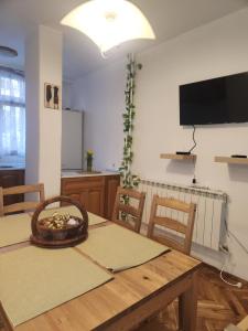 une cuisine et une salle à manger avec une table et une télévision dans l'établissement La Hasienda de Isabela, à Sofia