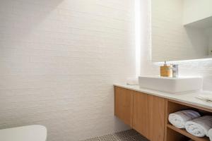 a white bathroom with a sink and a mirror at Casa Nova do Levante, perto do Mar in Olhão +24 photos