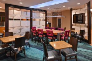 a dining room with tables and chairs and a television at SpringHill Suites by Marriott Voorhees Mt. Laurel/Cherry Hill in Voorhees