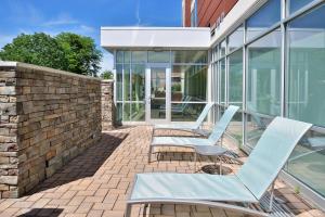 a patio with two lounge chairs on a brick wall at SpringHill Suites by Marriott Voorhees Mt. Laurel/Cherry Hill in Voorhees