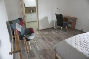 um quarto com 2 cadeiras, uma mesa e uma cama em Apartmán U Poštovských 