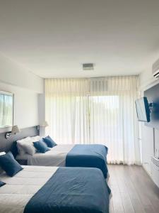 a hotel room with two beds and a flat screen tv at Golf Tower Suites & Apartments in Buenos Aires +65 photos