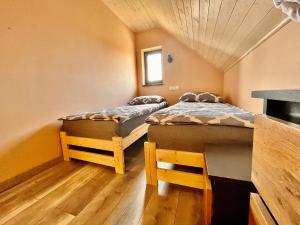 a room with two beds in a room at Apartament na Ogrodowej - 2 sypialnie, ogród, taras, parking in Trzęsacz