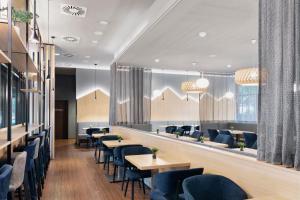 a restaurant with blue chairs and tables and a mirror at Residence Inn by Marriott Munich City East in Munich