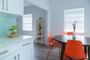 una cucina con tavolo da pranzo e sedie arancioni di Casa MIA central location, free parking, fully equipped a Miami