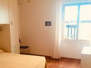 een slaapkamer met een bed en een raam bij Hotel La Stella in Seccheto