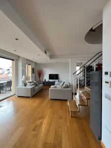 uma grande sala de estar com dois sofás e uma escada em Penthouse Suite - Skyline view em Busto Arsizio