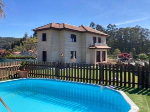 une maison avec une clôture et une piscine en face d'une maison dans l'établissement Sensacional Casa en Gondomar, à Gondomar