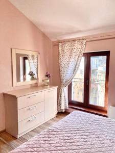 ヴァルナ・シティにあるRoman Thermae I Center Varna I Great Viewのベッドルーム1室(鏡付きドレッサー、窓付)
