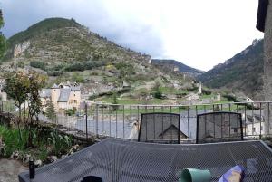 een uitzicht op een berg met huizen en een hek bij Ste ENIMIE GITE terrasse privative vue imprenable in Sainte-Énimie