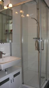 a bathroom with a glass shower and a sink at Strandnest in Karlshagen
