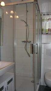 a shower with a glass door in a bathroom at Strandnest in Karlshagen