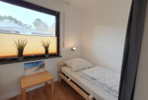 een kleine kamer met een bed en een raam bij Ferienwohnung Meerverliebt in Cuxhaven