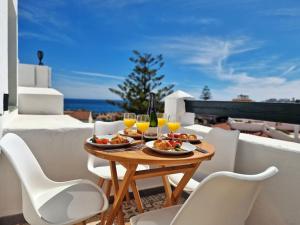 a table with food and wine glasses on a balcony at Hermoso Piso en La Cala de Mijas con vistas al mar in La Cala de Mijas