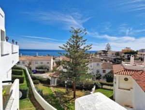 a tree in the middle of a city with the ocean at Hermoso Piso en La Cala de Mijas con vistas al mar in La Cala de Mijas
