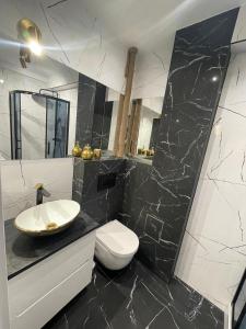 a black and white bathroom with a sink and a toilet at LUXURY GOLD APARTMENT by Marta in Radom +21 photos