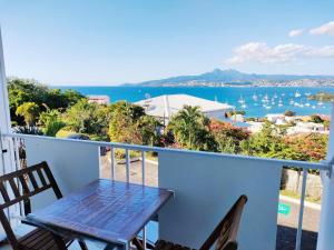 un tavolo e sedie su un balcone con vista sull'oceano di Chambre Antillaise a Les Trois-Îlets