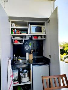 una piccola cucina con lavello e microonde di Chambre Antillaise a Les Trois-Îlets
