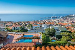 uma vista para uma cidade com casas e o oceano em Apartamentos Quinta Mae dos Homens em Funchal