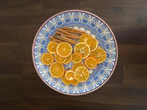 um prato azul e branco com fatias de laranja e paus de canela em Azalea Biznaga em Torre de Benagalbón