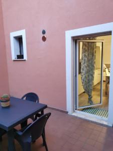 a patio with a table and chairs and a sliding glass door at La casa delle stagioni in LʼAquila