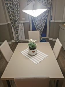 biały stół jadalny z doniczką w obiekcie La casa delle stagioni w mieście LʼAquila