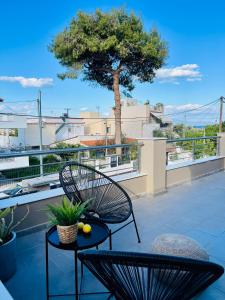 une terrasse avec 2 chaises, une table et un arbre dans l'établissement Abuelo Apartment, à Artemi