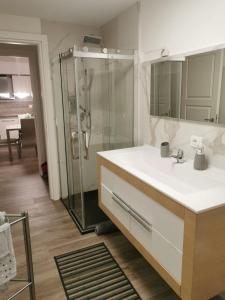 a bathroom with a sink and a glass shower at La casa delle stagioni in LʼAquila