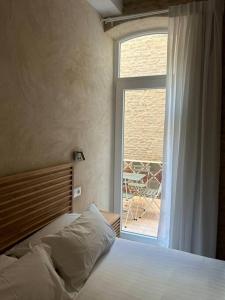 um quarto com uma cama e uma janela com um pátio em Casa Procurador Triana em Sevilha