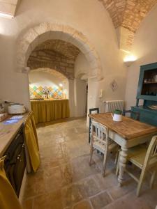 a kitchen with a wooden table in a room at PalazzOliva - Boho chic Guest house in the historic heart of Martina Franca in Martina Franca