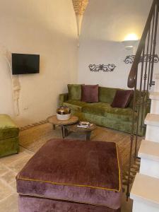 a living room with a couch and a table at PalazzOliva - Boho chic Guest house in the historic heart of Martina Franca in Martina Franca