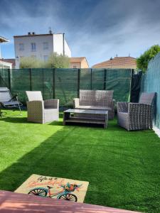 d'une terrasse avec des chaises et une table sur la pelouse. dans l'établissement Studio Moana avec parking et jardin, à La Londe-les-Maures