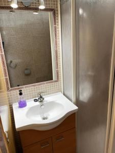 a bathroom with a sink and a mirror and a shower at Apartamento en primera linea de playa con vistas in Puerto de Mazarrón +35 photos