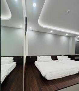 Cette chambre comprend 2 lits avec des draps et des oreillers blancs. dans l'établissement BITA HOTEL CẦN THƠ, à Bình Thủy